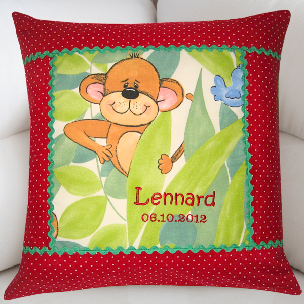 Personalisiertes Namenskissen aus Baumwolle 40 × 40 cm mit niedlichem Affen-, Löwen oder Giraffenmotiv, rotem gepunktetem Rand, grüner Zackenlitze und individueller Bestickung mit Wunschname – handgefertigtes Kinderkissen.